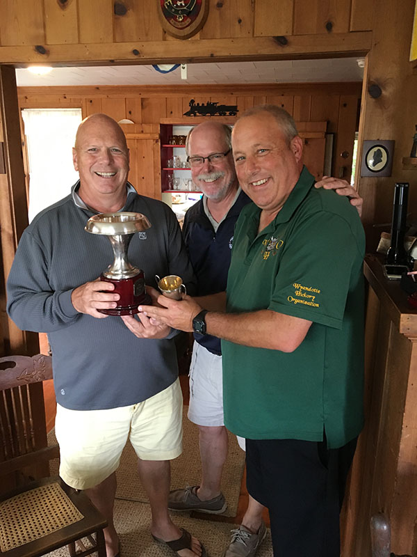Capt. Trapani, left, and Jim Davis congratulate Bill Ellington, right, on his new status as a McNabb Cup champion.